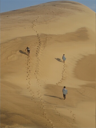 Cheryl scrambling up a huge dune
